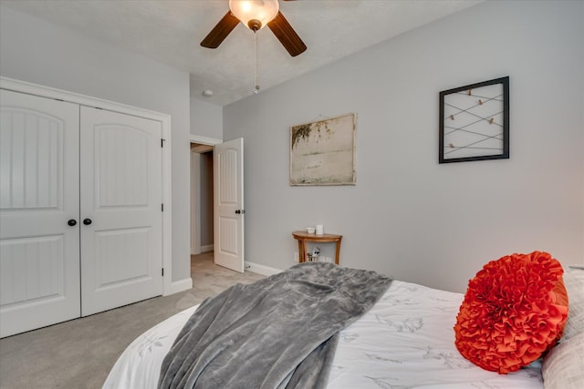 bedroom featuring light carpet, a closet, a ceiling fan, and baseboards
