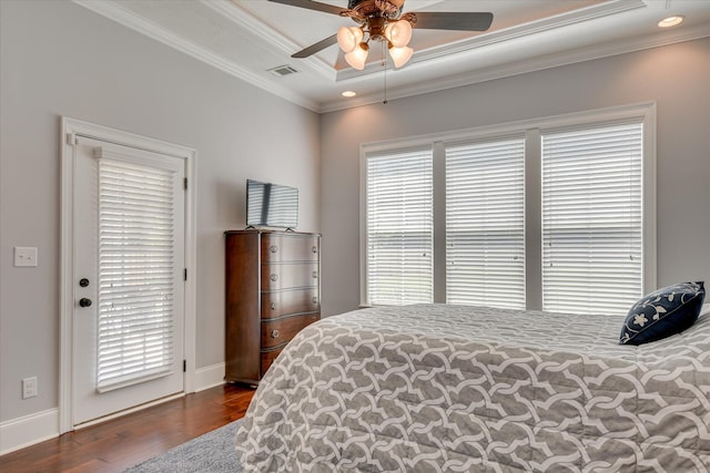 bedroom with wood finished floors, a raised ceiling, crown molding, baseboards, and ceiling fan