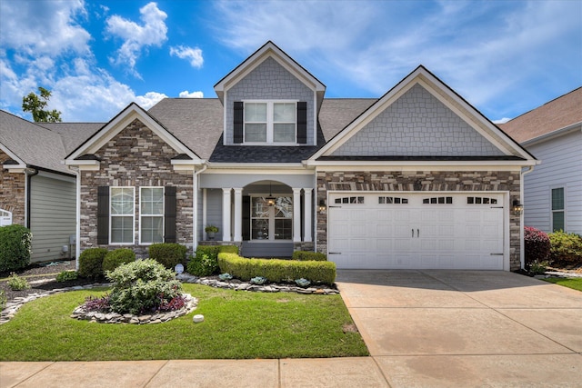 craftsman-style house with stone siding, concrete driveway, a front lawn, a garage, and a shingled roof