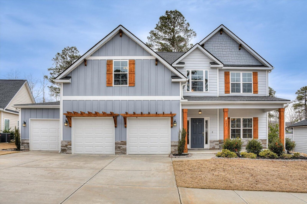 craftsman inspired home featuring a garage, central AC unit, and covered porch