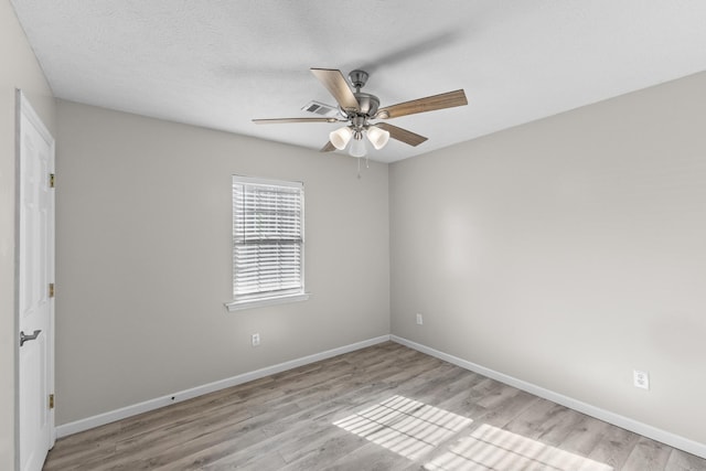 empty room with a textured ceiling, light hardwood / wood-style flooring, and ceiling fan