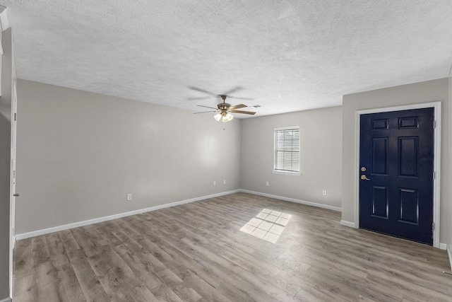 foyer entrance featuring ceiling fan, light wood-type flooring, and a textured ceiling