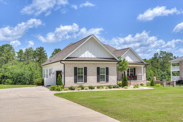670 Callaway Dr, Graniteville, SC 29829 - view of front facade featuring board and batten siding, brick siding, a front yard, and covered porch