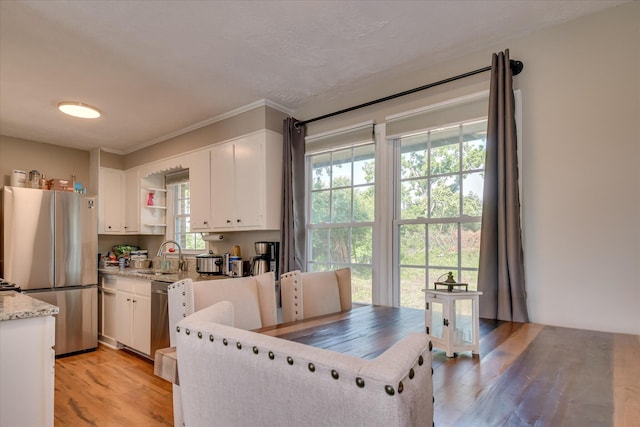 2013 Lamar Rd, Augusta, GA 30904 - kitchen featuring stainless steel appliances, a sink, white cabinets, light wood-type flooring, and light stone countertops
