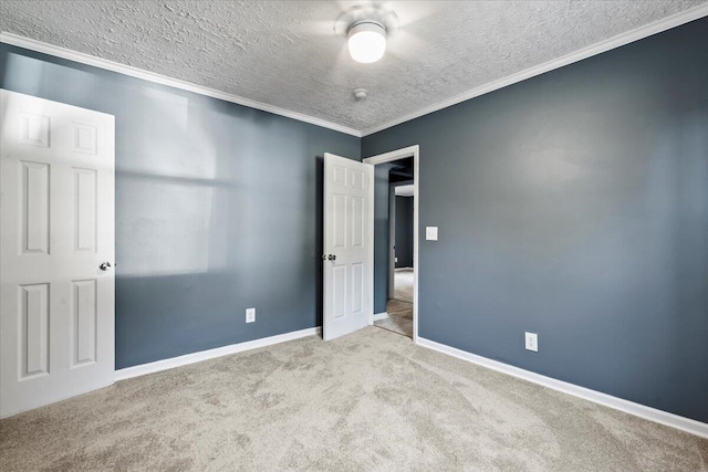 carpeted empty room with ornamental molding and a textured ceiling