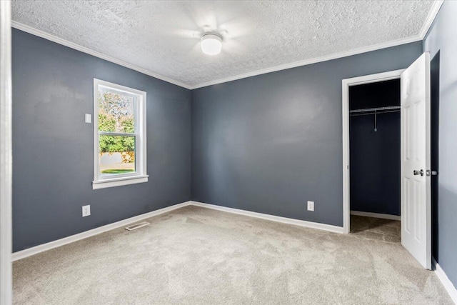 unfurnished bedroom featuring ceiling fan, a closet, light colored carpet, and a textured ceiling