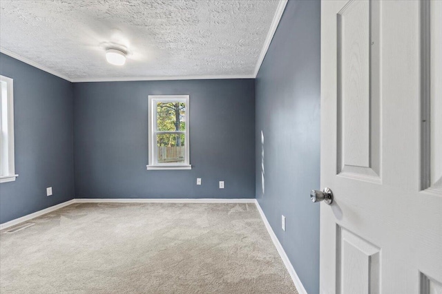 carpeted empty room with ornamental molding and a textured ceiling