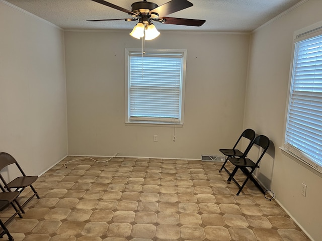 unfurnished room with a textured ceiling, plenty of natural light, ceiling fan, and crown molding