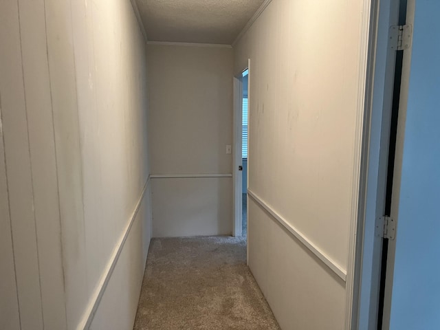 hall featuring a textured ceiling and light colored carpet