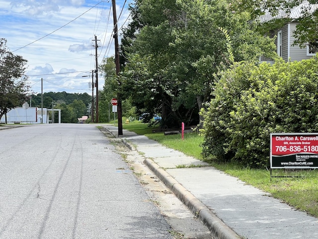 404 King St, Wrens, GA 30833 - view of asphalt road featuring sidewalks, traffic signs, and curbs