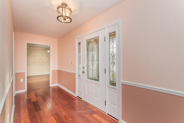 foyer entrance featuring dark hardwood / wood-style floors and a chandelier