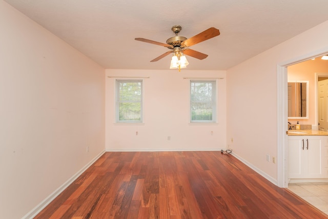 spare room with ceiling fan, hardwood / wood-style floors, and sink