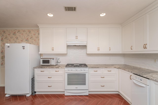 kitchen featuring white cabinets, light stone countertops, white appliances, and dark parquet flooring