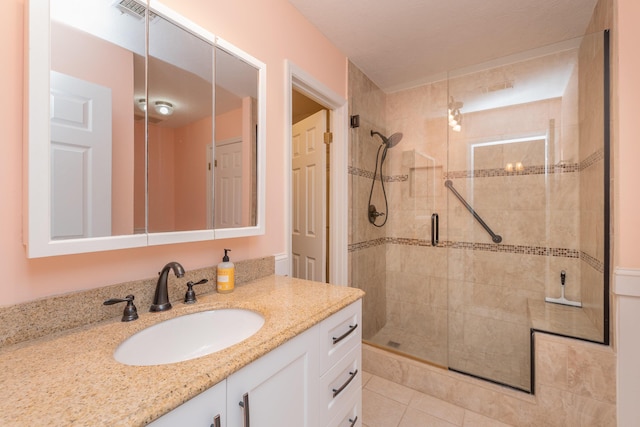 bathroom with tile patterned flooring, vanity, and a shower with shower door