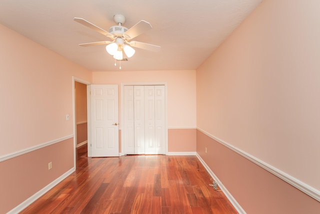 unfurnished bedroom with ceiling fan, a closet, and dark hardwood / wood-style floors