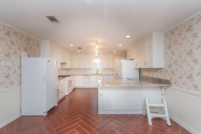 kitchen featuring white appliances, sink, kitchen peninsula, ornamental molding, and white cabinetry