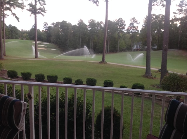 view of community with view of golf course and a lawn