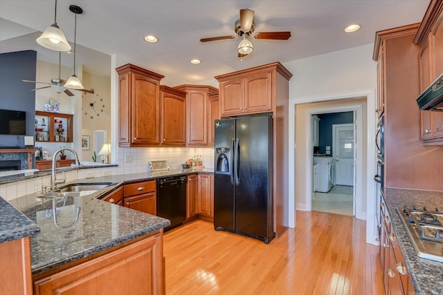 kitchen with ceiling fan, a sink, backsplash, black appliances, and washer and clothes dryer