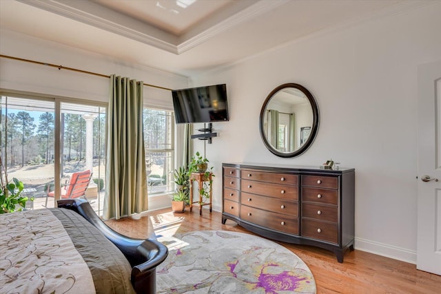 bedroom with light wood-style flooring, access to exterior, baseboards, a raised ceiling, and crown molding