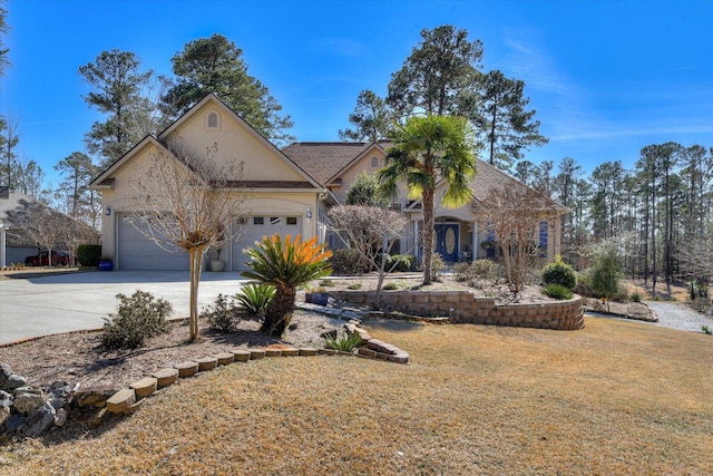 view of front of home featuring driveway, an attached garage, a front lawn, and stucco siding