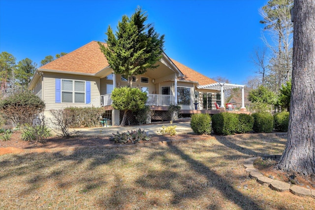 view of front of house with a shingled roof, a pergola, and a wooden deck