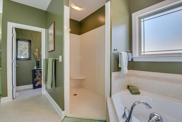 bathroom featuring baseboards, walk in shower, a bath, and tile patterned floors