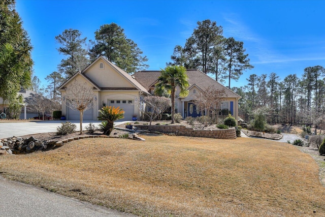 view of front of house featuring a garage, a front yard, and concrete driveway