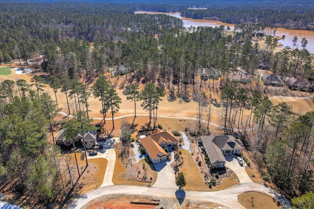 birds eye view of property with a water view and a wooded view