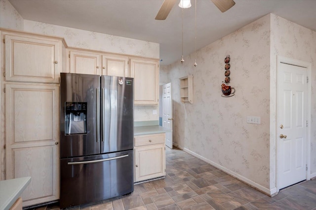 kitchen featuring stainless steel refrigerator with ice dispenser, light countertops, ceiling fan, baseboards, and wallpapered walls