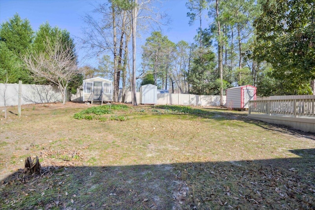 view of yard featuring a fenced backyard, a storage unit, and an outbuilding