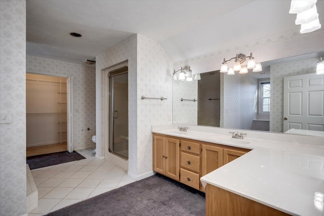 bathroom featuring tile patterned floors, a stall shower, a sink, and wallpapered walls