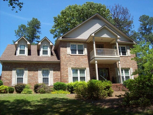 567 Lakeside Dr, Aiken, SC 29803 - view of front of house featuring a balcony, brick siding, and a front lawn