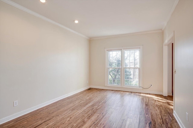 spare room with ornamental molding, recessed lighting, light wood-style flooring, and baseboards