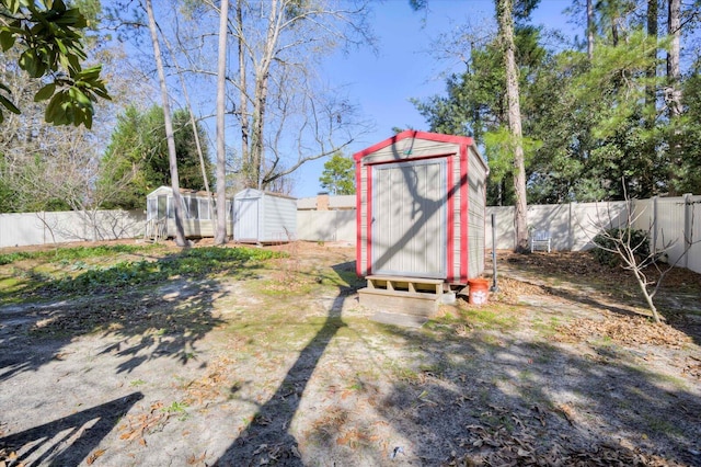 view of yard with an outbuilding, a shed, and a fenced backyard