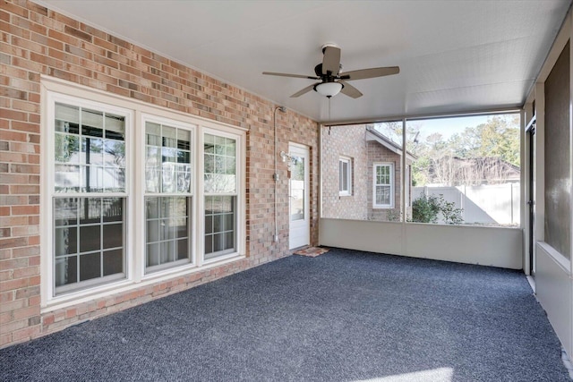 unfurnished sunroom featuring a ceiling fan