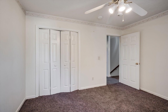 unfurnished bedroom featuring baseboards, dark carpet, ceiling fan, and a closet