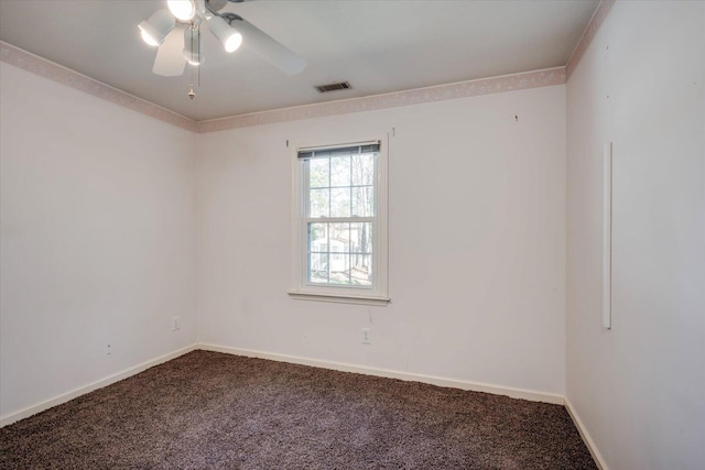 carpeted spare room with a ceiling fan, visible vents, baseboards, and crown molding