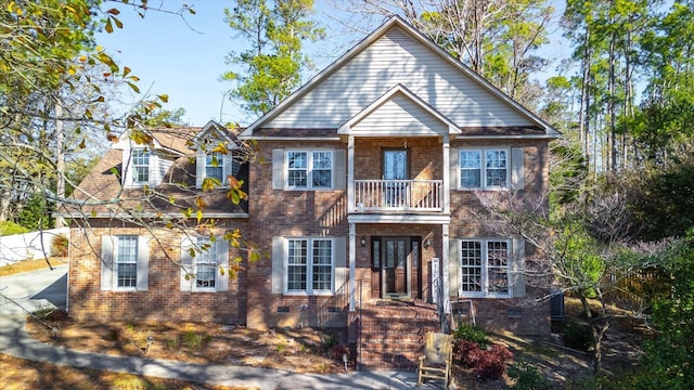 view of front of house with crawl space, a balcony, and brick siding