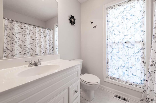 bathroom featuring tile patterned flooring, vanity, and toilet