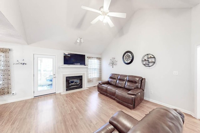 living room featuring high vaulted ceiling, ceiling fan, light hardwood / wood-style floors, and a wealth of natural light