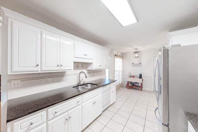 kitchen with dishwasher, sink, light tile patterned floors, stainless steel fridge, and white cabinets