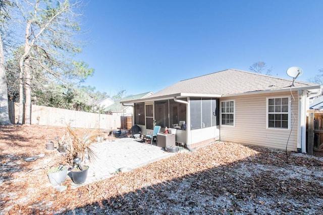 rear view of house featuring a sunroom and a patio