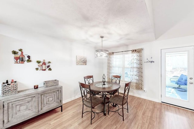 dining area featuring light wood-type flooring and an inviting chandelier