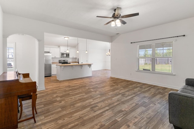 7058 Summerton Dr, Augusta, GA 30909 - living room with arched walkways, baseboards, ceiling fan with notable chandelier, and dark wood finished floors