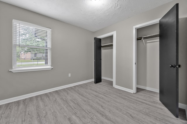 3808 Southfield Dr, Augusta, GA 30906 - unfurnished bedroom featuring two closets, wood finished floors, a textured ceiling, and baseboards