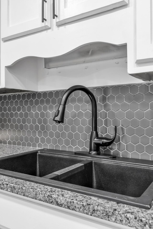 3808 Southfield Dr, Augusta, GA 30906 - kitchen view of a sink, backsplash, white cabinetry, and light stone countertops