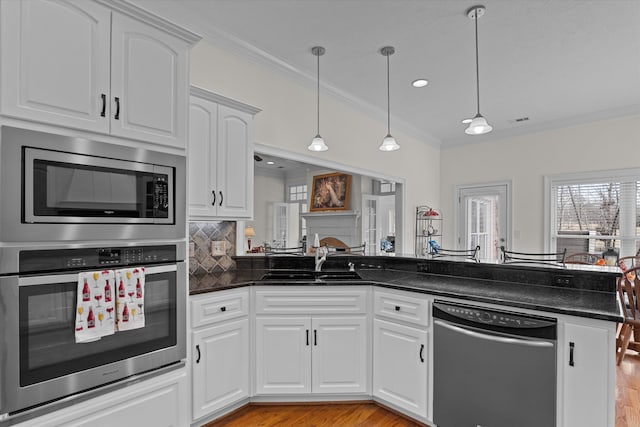 kitchen with visible vents, a sink, ornamental molding, stainless steel appliances, and tasteful backsplash