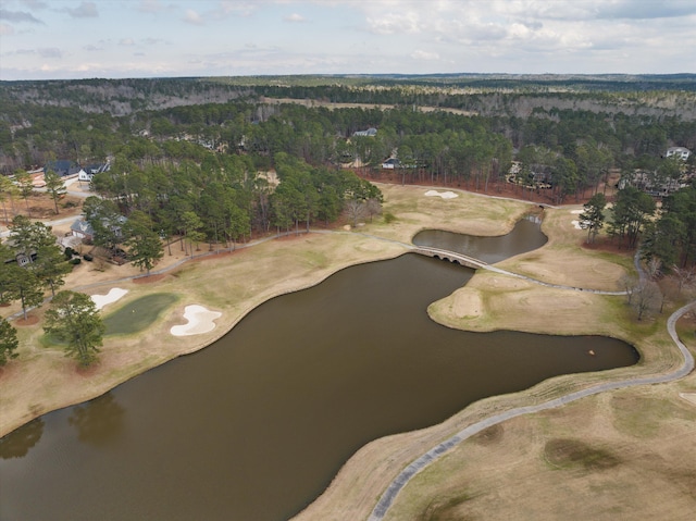 aerial view featuring a wooded view, view of golf course, and a water view