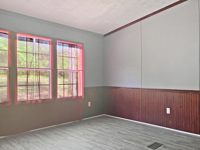 4112 Quail Farm Rd, Thomson, GA 30824 - spare room with visible vents, a textured ceiling, wood finished floors, and wainscoting