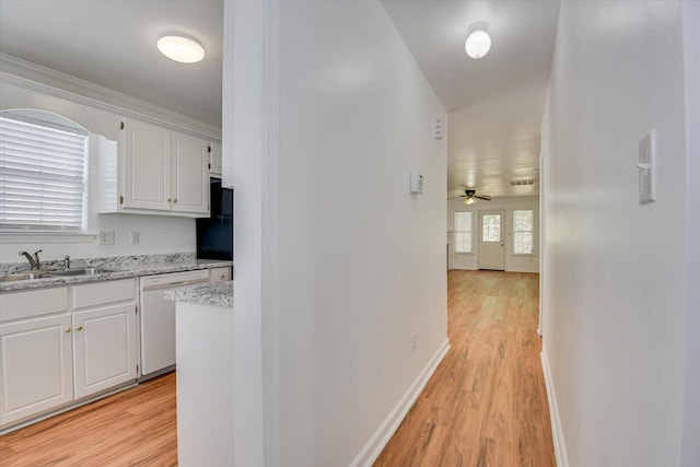 hallway featuring crown molding, sink, and light wood-type flooring